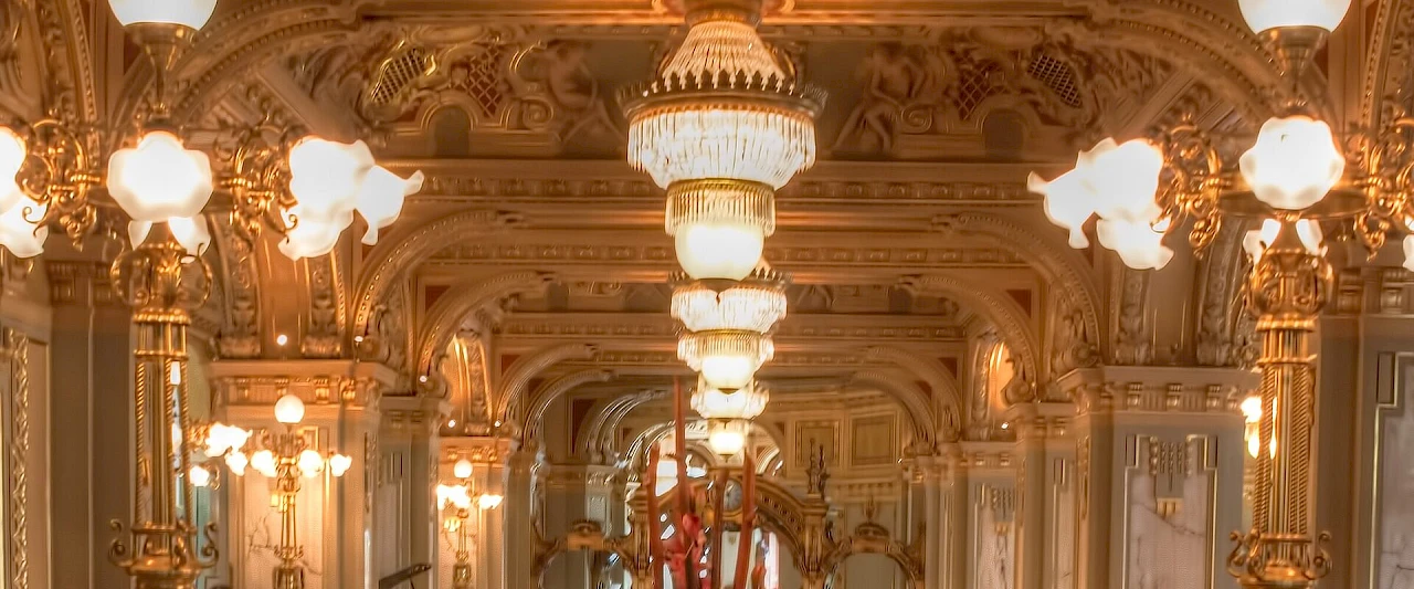 La sala del New York Café di Budapest, con stucchi dorati, colonne e lampadari